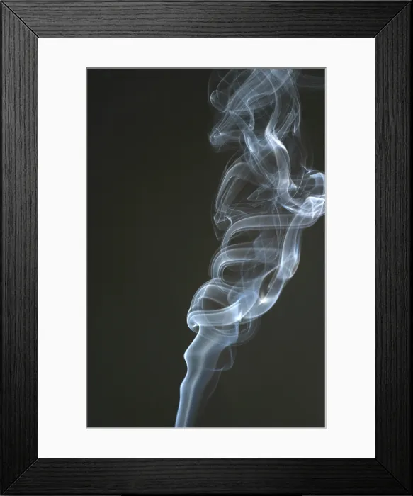 Framed Print : Smoke from a cigarette is frozen in motion by a high-speed flash