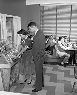 Playing Prints: Teen couple playing jukebox, c. 1950s, Vintage nostalgia